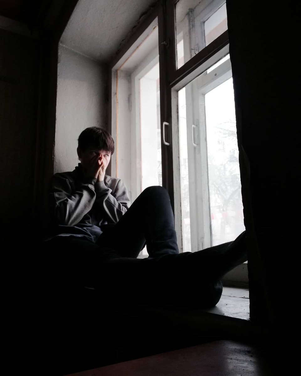 Парень сидит на подоконнике