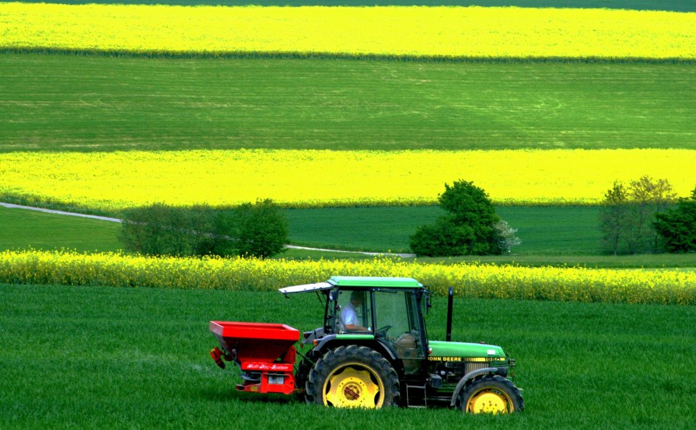 Трактор John Deere на зеленом поле