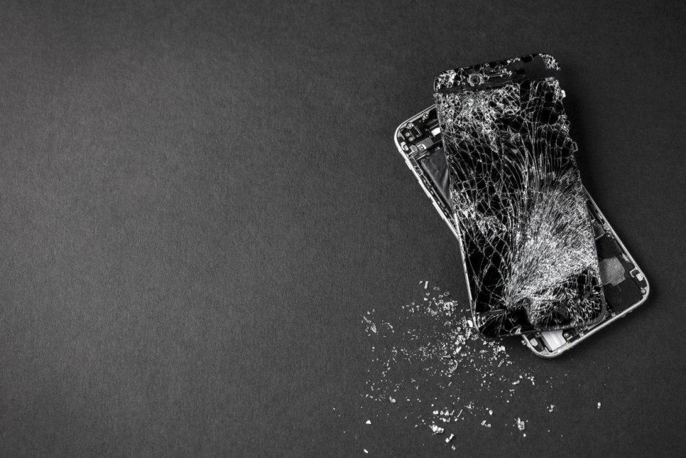 Разбитый мобильный на черном фоне